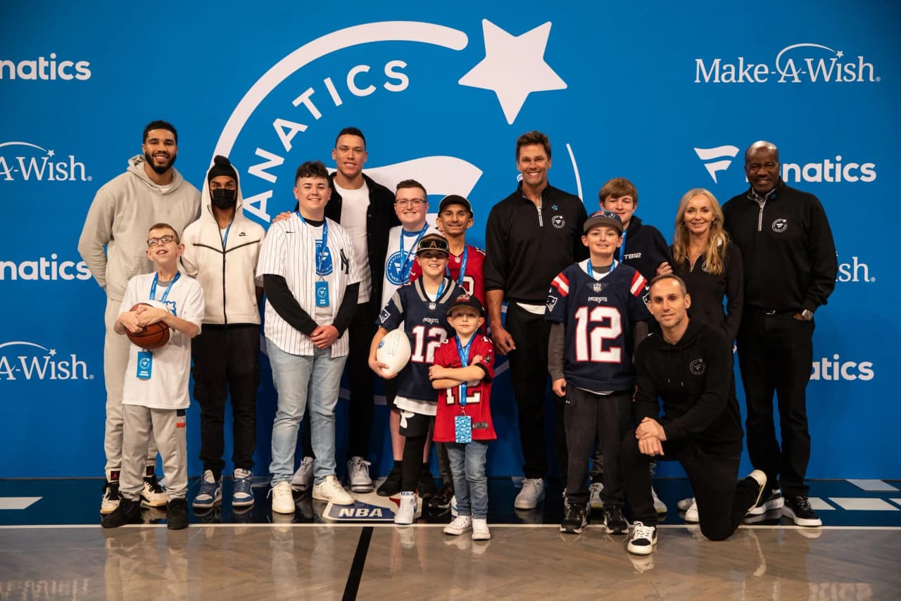 Children and athletes posing together at a Make-A-Wish event